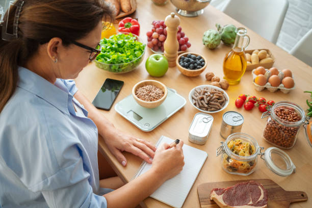 A calm kitchen table with a weekly meal planning notebook, seasonal produce, and warm morning light